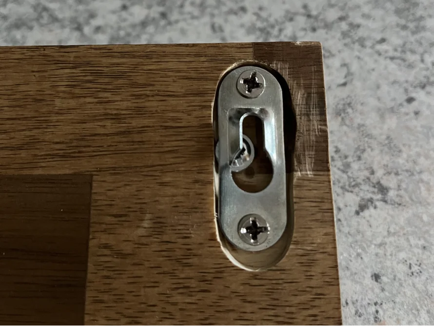 Metallhalterung an Holzbrett