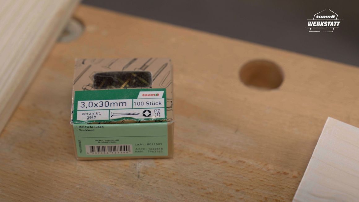 Eine Packung gelber Schrauben auf einem Holztisch