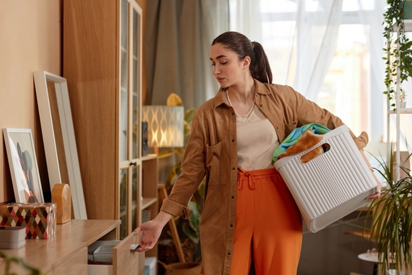 Frau hat Box unterm Arm und räumt auf