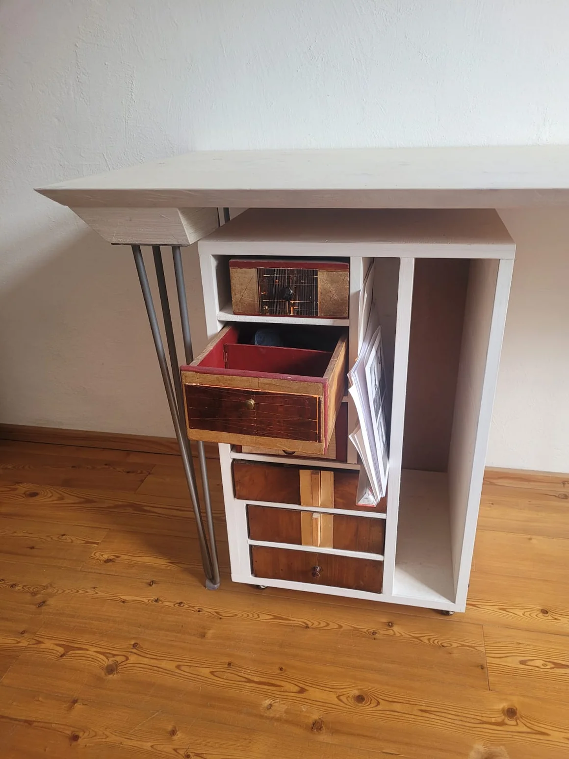 Weißer Beistelltisch aus wiederverwendeten Schubladen und modernen Metallbeinen.