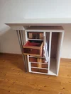 Weißer Beistelltisch aus wiederverwendeten Schubladen und modernen Metallbeinen.