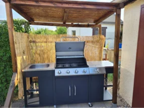 Gasgrill unter einem Holzdach