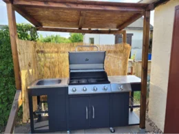 Gasgrill unter einem Holzdach