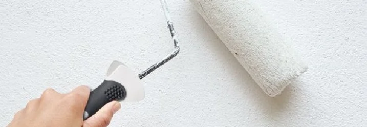 Hand streicht Wand weiß