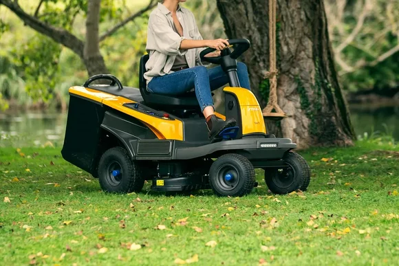 Person mäht Rasen mit einem Aufsitzrasenmäher