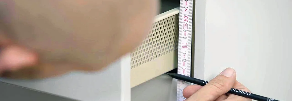 Person misst mit Zollstock an Küchenschrank