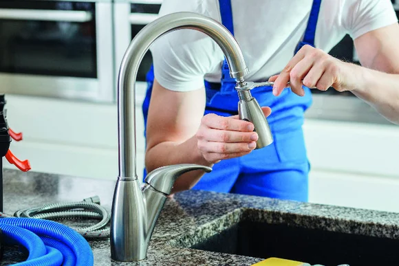 Person montiert Wasserhahn.