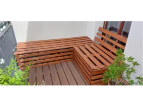 Ecksitzbank aus Holz auf einem Balkon