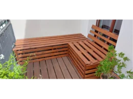 Ecksitzbank aus Holz auf einem Balkon
