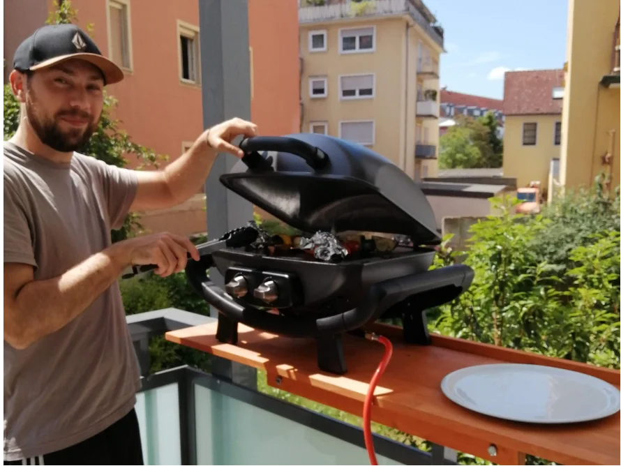 Person grillt auf einem Balkon
