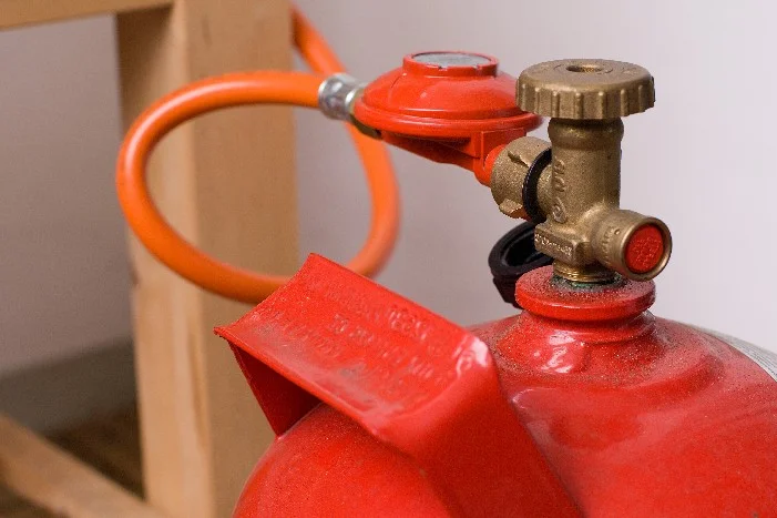 Rote Gasflasche mit Druckminderer