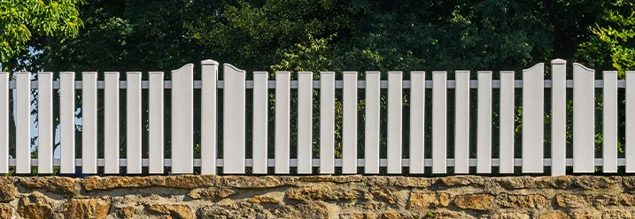 Weißer Holzzaun auf Steinmauer
