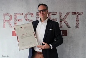 Geschäftsführer von toom Baumarkt hält Beruf und Familie Zertifikat in der Hand