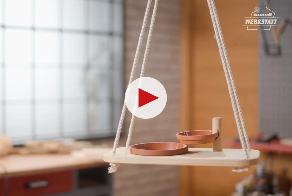 Vogeltränke aus Ton auf Holzbrett