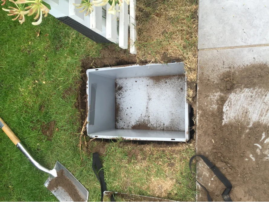 Graue Kiste im Loch im Boden