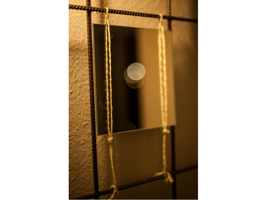 Spiegel an Wand mit Schnur befestigt