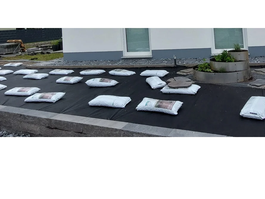 Gartenfläche mit Säcken auf Vlies