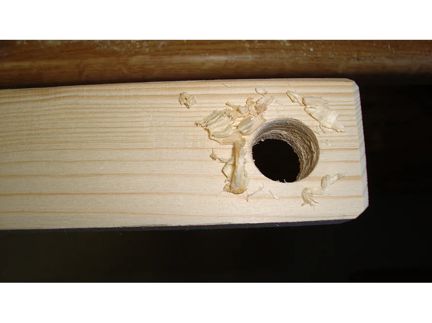 Holz mit Loch und Sägespänen