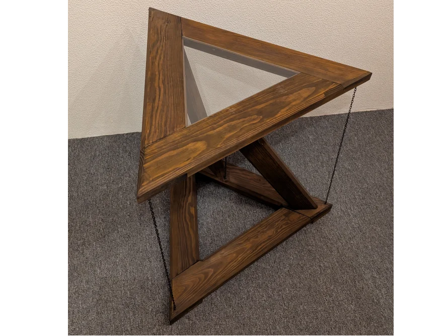 Dreieckiger Tisch aus dunklem Holz mit Glasplatte