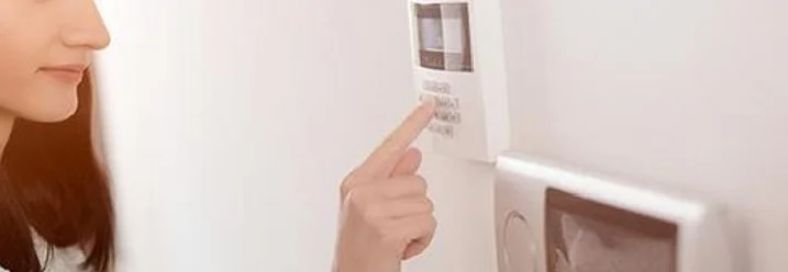 Person gibt Code an Alarmanlage ein