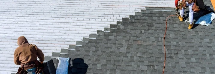 Zwei Personen decken ein Dach