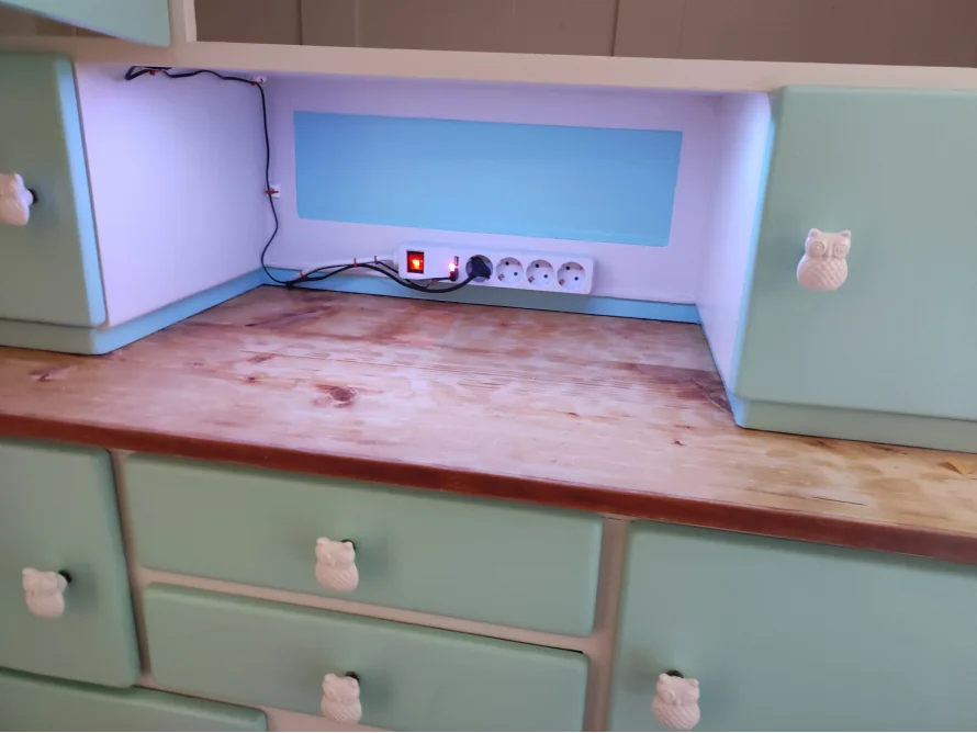 Ecke einer mintgrünen Kommode mit Holzoberfläche