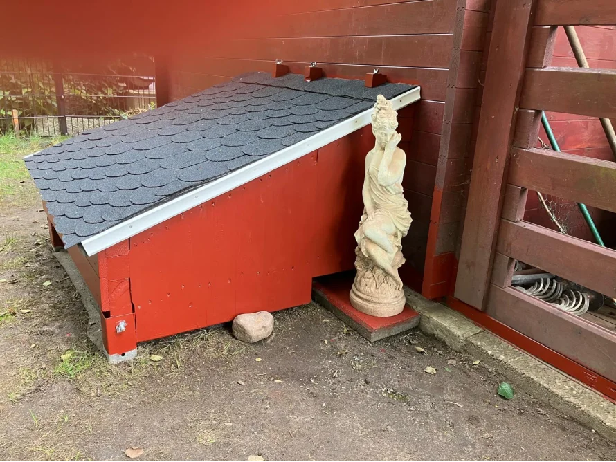 Rotes Gartenhaus mit schwarzem Dach