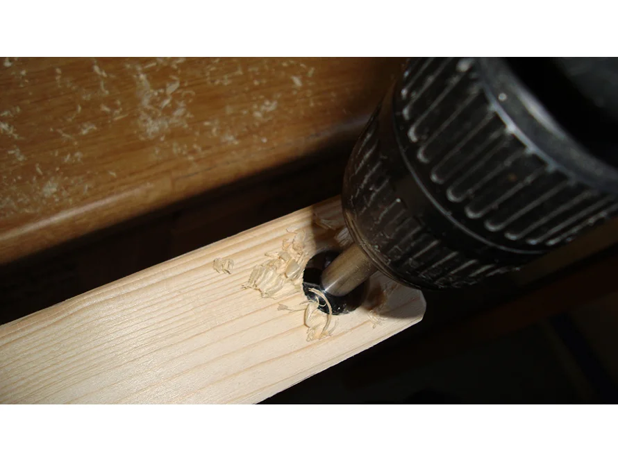 Bohrer bohrt Loch in Holzlatte