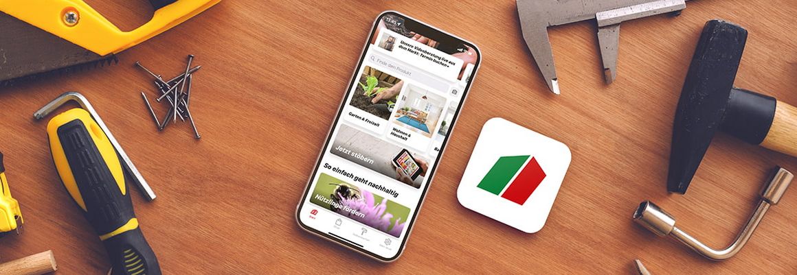 Handy liegt neben Werkzeugen und toom App-Icon