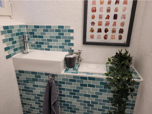 Kleines Bad mit grün gefliester Wand