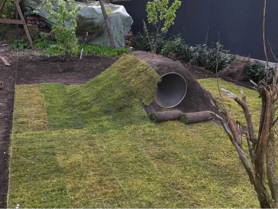 Rasen mit Erdhügel und Rohr