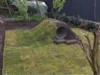 Rasen mit Erdhügel und Rohr