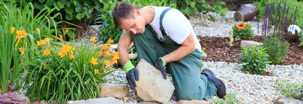 Person beim Verlegen von Steinen