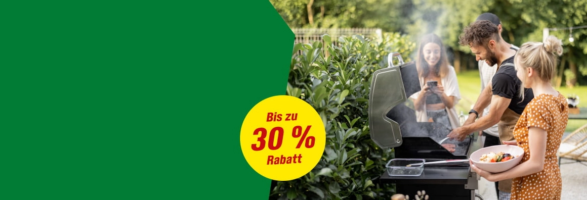 Eine Gruppe von Personen grillt gemeinsam in einem Garten.