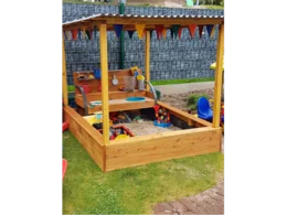Überdachter Sandkasten mit Spielzeug