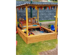 Überdachter Sandkasten mit Spielzeug
