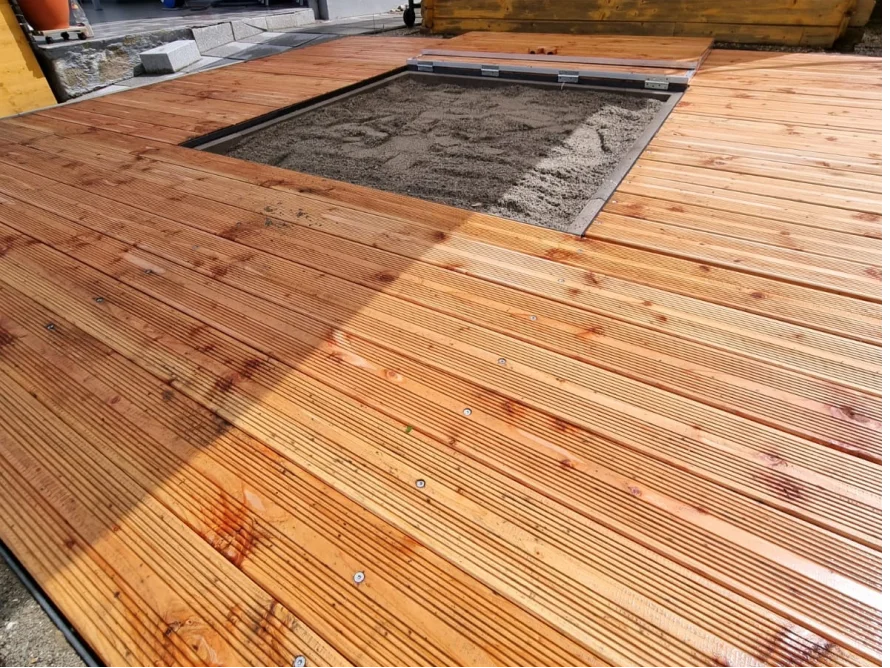 Holzterrasse mit Sandkasten
