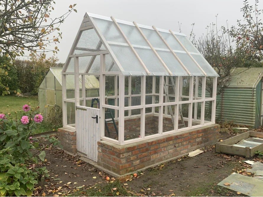 Gartenhaus mit Glasdach und Ziegelsteinsockel