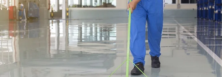 Person reinigt Boden mit Wischmopp