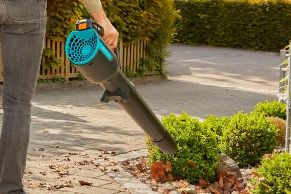 Person verwendet Laubbläser im Garten