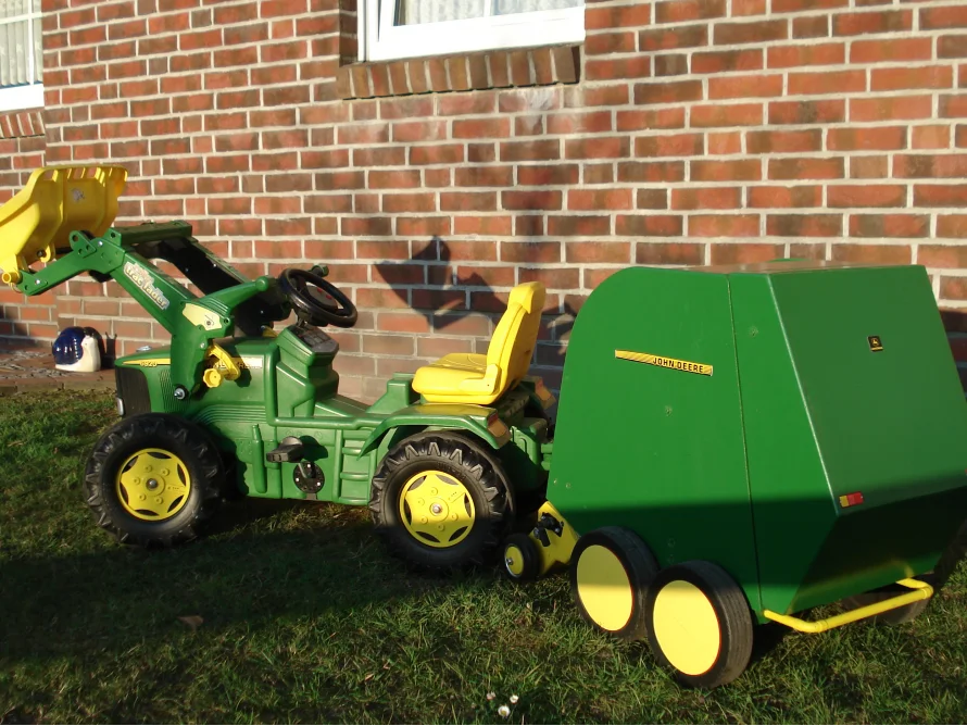 Grünes Spielzeugtraktor mit Anhänger