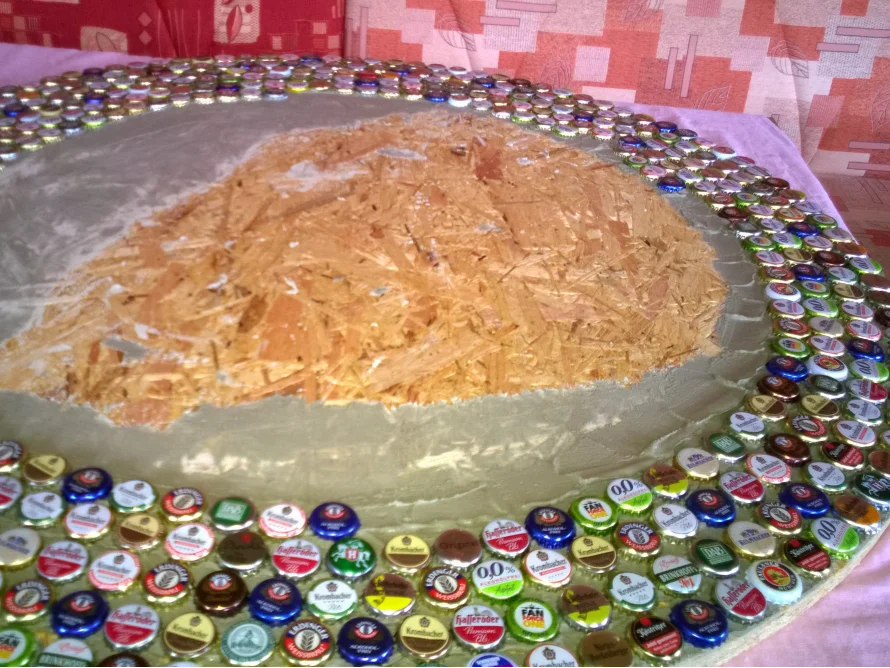 Tischplatte wird mit Kronkorken beklebt