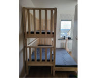 Ein Hochbett aus hellem Holz mit zwei übereinanderliegenden Liegeflächen