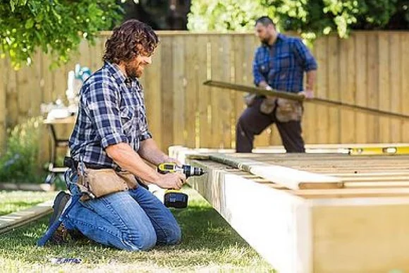 Zwei Personen bauen eine Holzterrasse