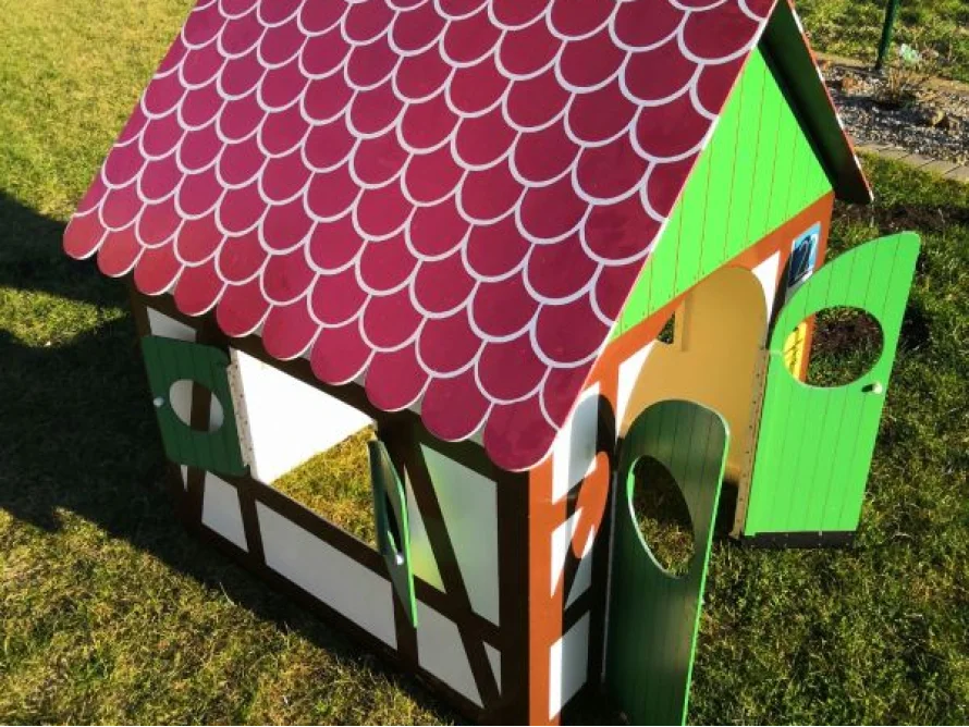 Spielhaus mit rotem Dach und grünen Fensterläden