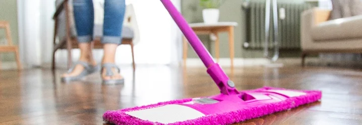 Person wischt mit Wischmopp Holzboden