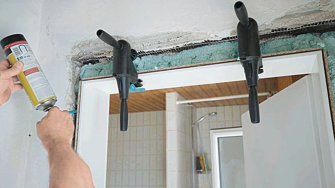 Person bringt Montageschaum an Türrahmen an