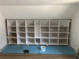 Ein teilweise gebautes, weißes Holzregal.