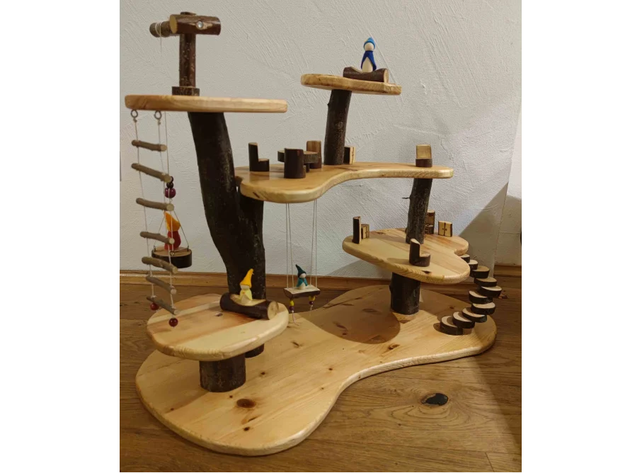 Ein mehrstöckiges Baumhaus-Spielzeug aus Holz mit Leitern, Schaukeln und kleinen Figuren.