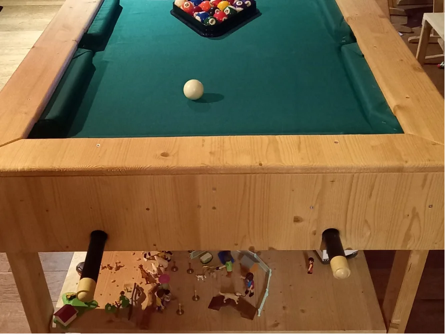 Billardtisch aus Holz mit Spielzeug darunter